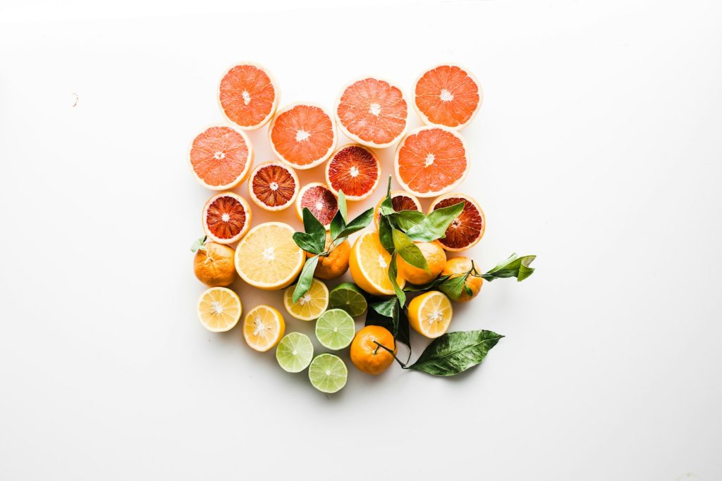 Assortiment d agrumes et fruits colores riches en vitamine C, poses sur une surface claire