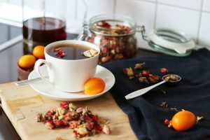 Tasse de tisane fumante et oranges fraîches sur une table en bois, lumière naturelle douce